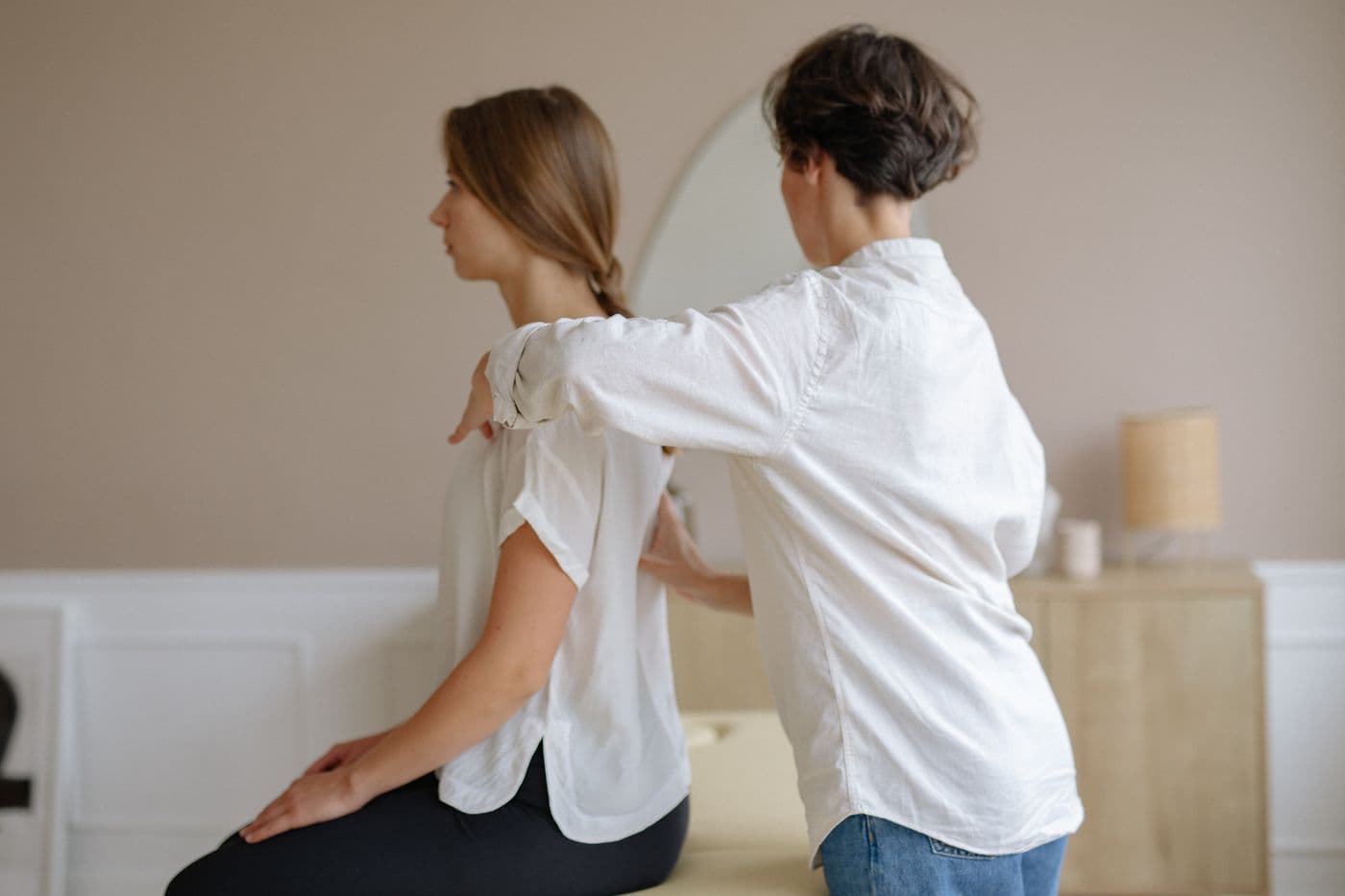 Therapist assessing a patient's shoulder posture