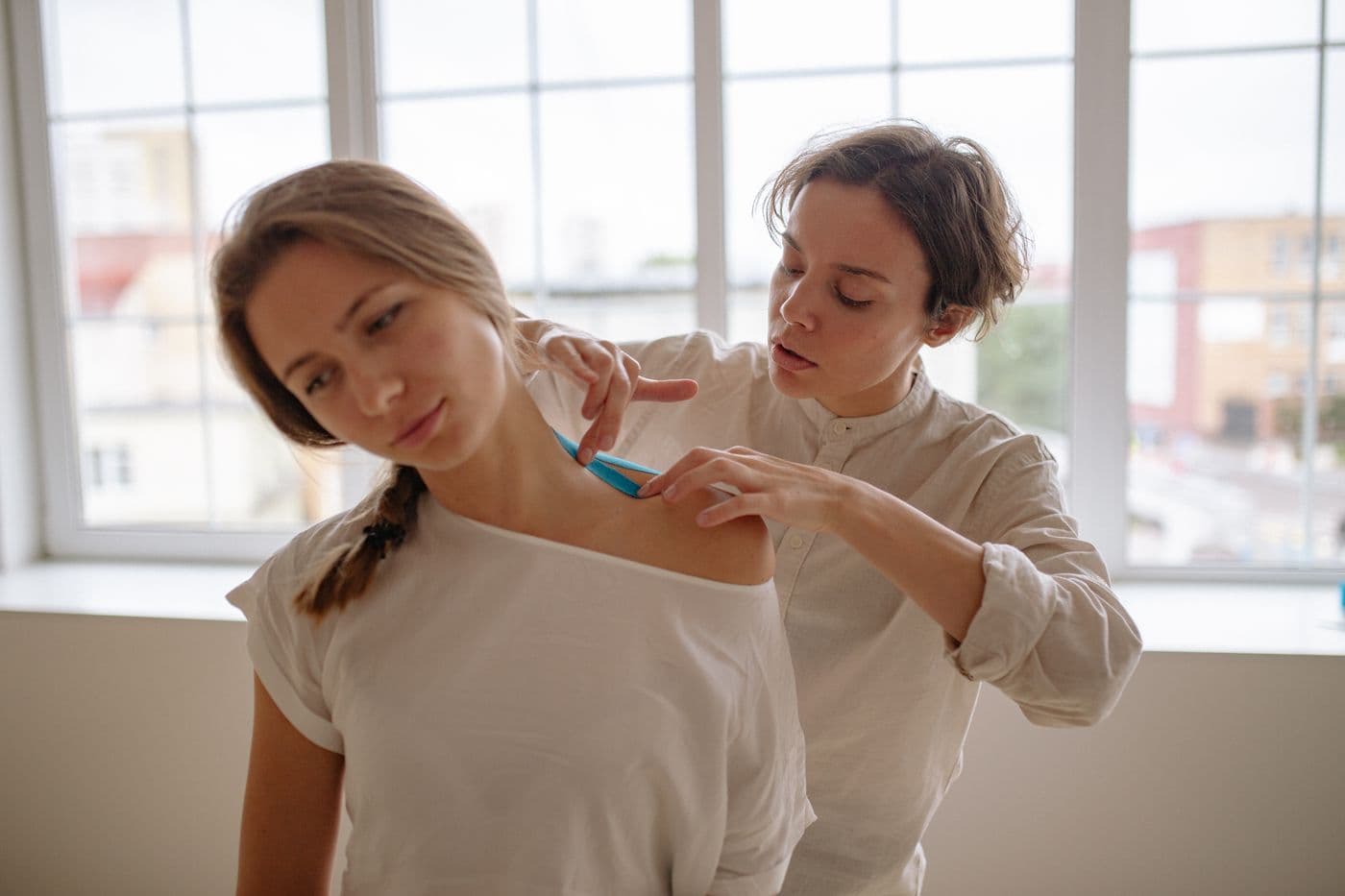 Therapist applying support tape to a patient's shoulder