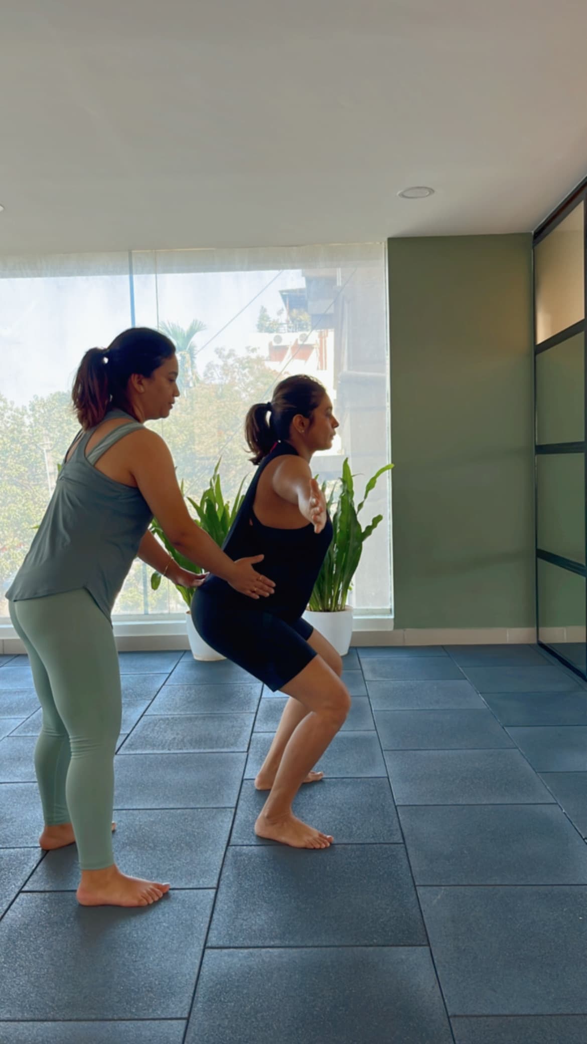 Physiotherapist guiding a patient through a leg stretch at home